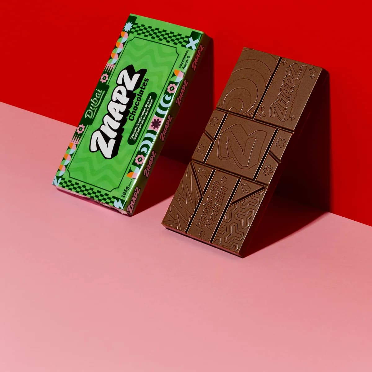 Empaque verde de Dubai junto a la barra de chocolate sin envolver.