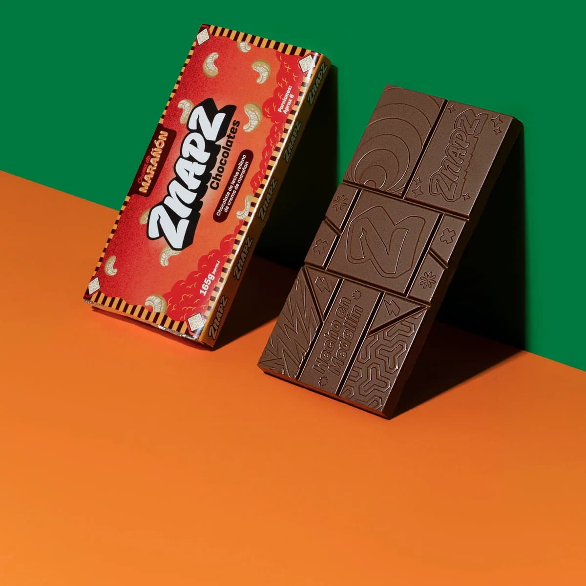 Empaque rojo de Marañón junto a la barra de chocolate sin envolver.